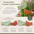 Handcrafted ceramic garden stakes with birds and floral designs on a garden background.